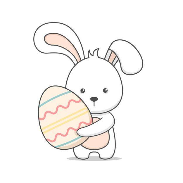 Милый пасхальный кролик держит яйцо