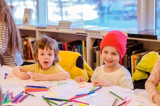 Маленькие дети рисуют вместе в дневном детском саду