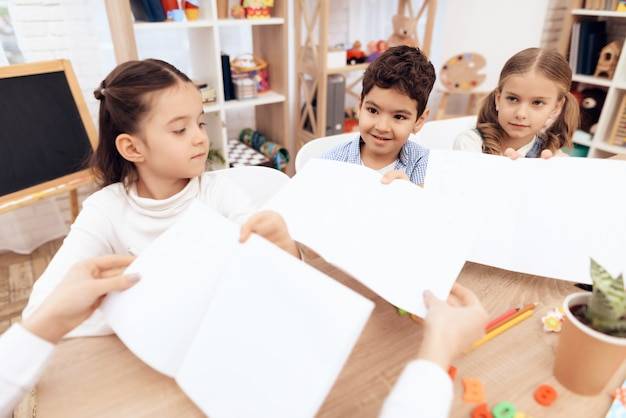 Дети в детском саду показывают свои рисунки