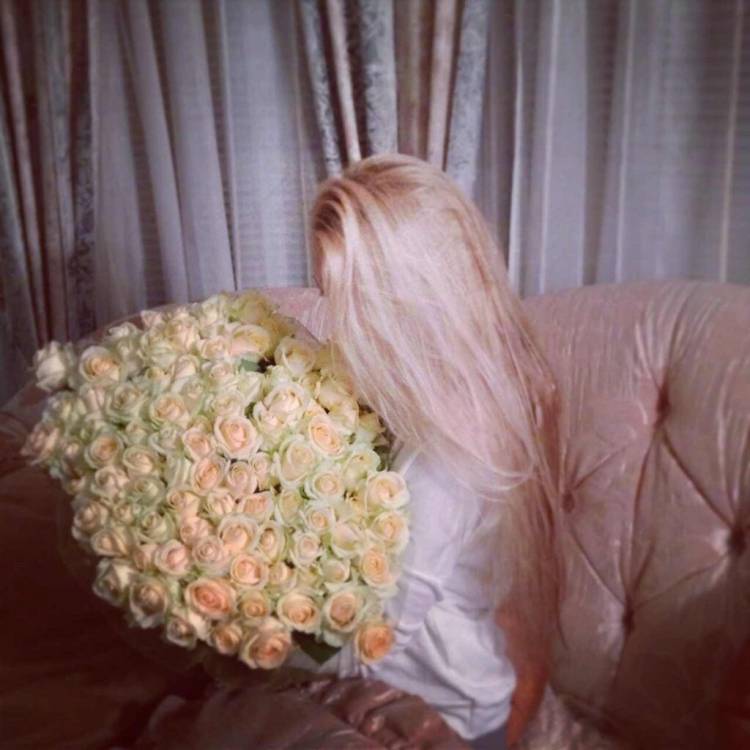 Девушка блондинка со спины с цветами